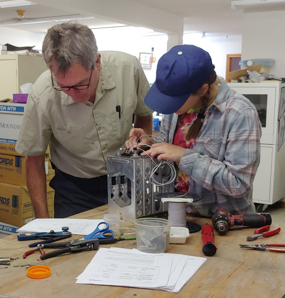 Student and mentor work on avionics wiring